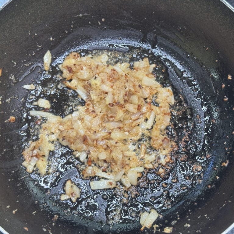 手順 1: 温めたフライパンに油を熱しみじん切りした玉ねぎを飴色まで炒めおろしニンニク・生姜を炒め合わせる。