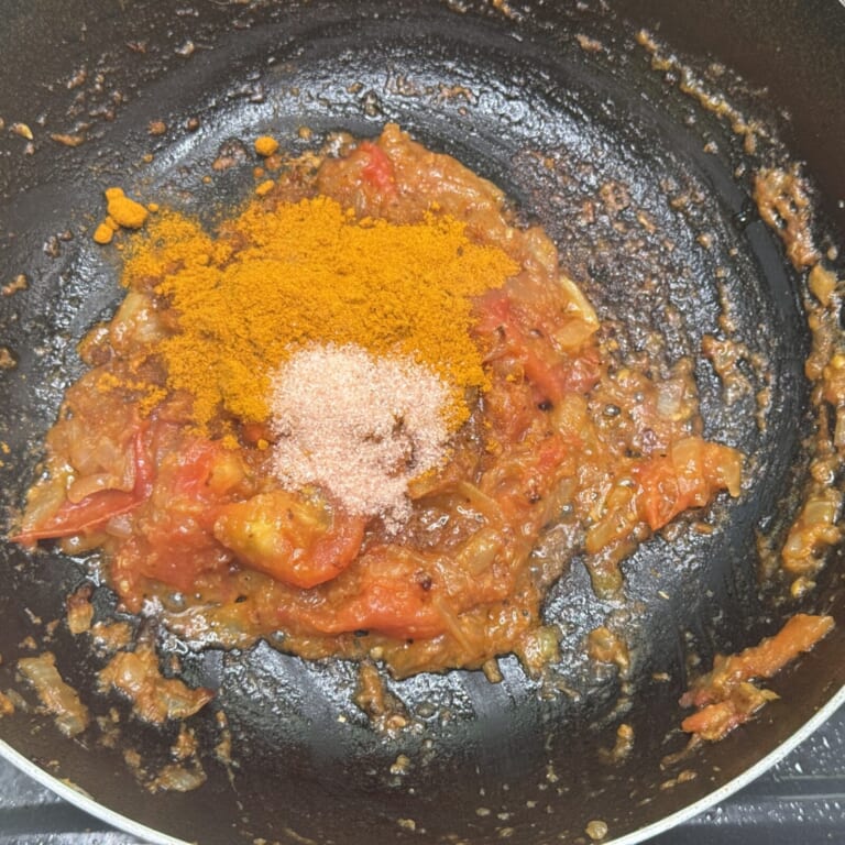 手順 2: トマトを加え水分が飛ぶまで炒めたらカレーパウダー、塩を加え炒め合わせ、カレーペーストを作る。