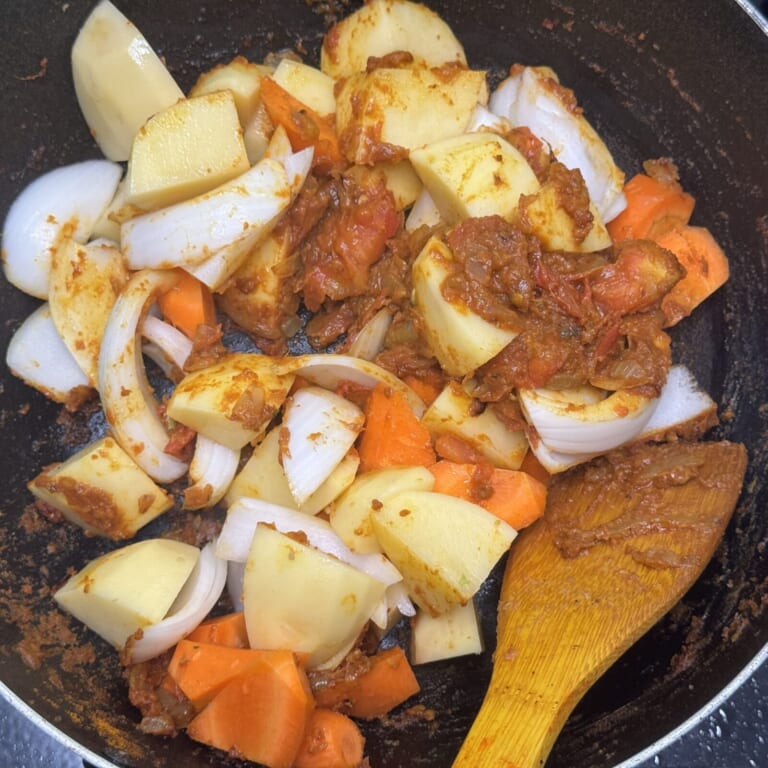 手順 3: 温めた深めのフライパンにカレーペーストを加え肉を入れ炒め合わせ色が変わってきたらジャガイモ、玉ねぎ、人参を加え炒め合わせ