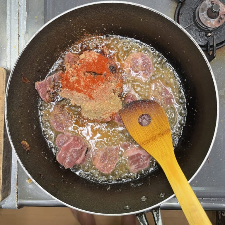 手順 2: 玉ねぎを取り除いた油にニンニク、生姜を加え火が通ったらラム肉、スパイスA、塩を加えてラム肉の表面に火が通るまで煮込みむ。