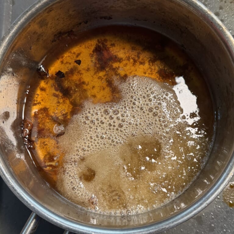 手順 2: 秋刀魚を素揚げした油の温度を冷ましてからスパイスA、を熱し香りが立ってきたらニンニク・生姜を加え火を通す。