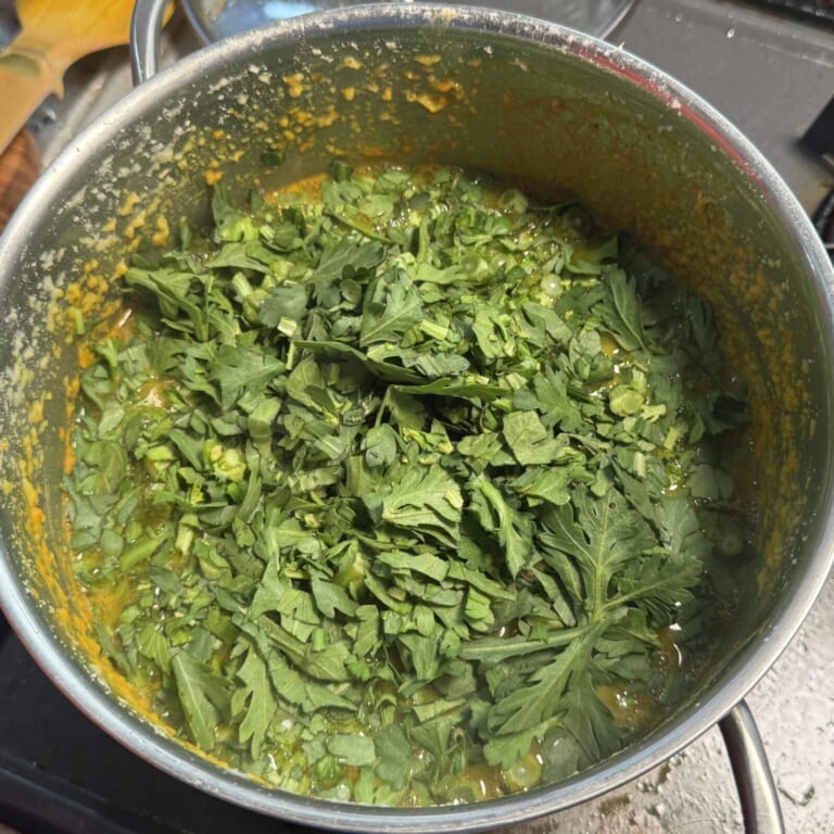 手順 3: 豆とトマトが煮崩れてきたら、塩と春菊を入れる。