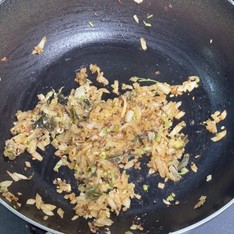 手順 3: 玉ねぎを加え、飴色まで炒まったらおろしニンニク・生姜を炒め合わせる。