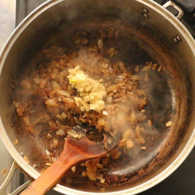 手順 5: カルダモンからシュワシュワと音がしてきたら、玉ねぎを加えてあめ色でねっとりするくらいまで炒め、にんにく、生姜を加えます。