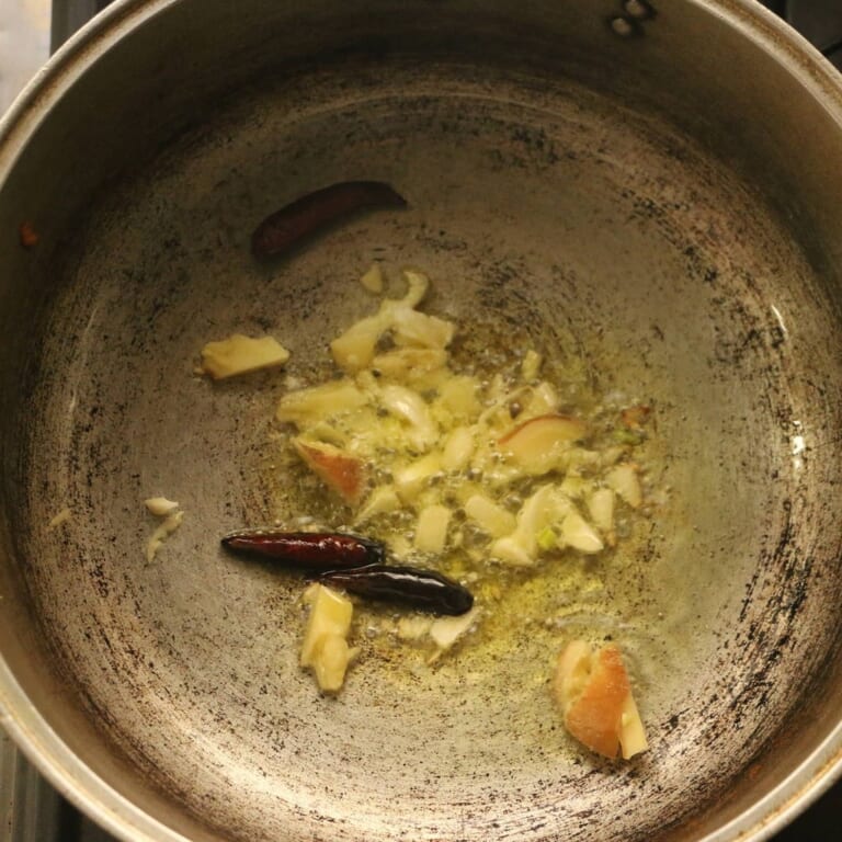 手順 1: 鍋にサラダ油を中火で熱し、スパイスB(レッドペッパー)、にんにく、生姜を炒めます。