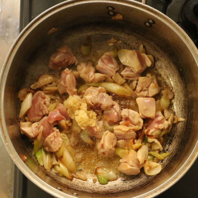 手順 3: 香ばしい匂いが出てきたら、鶏肉を加えます。 表面に火が通ったら、にんにくと生姜を加え、更に炒めます。
