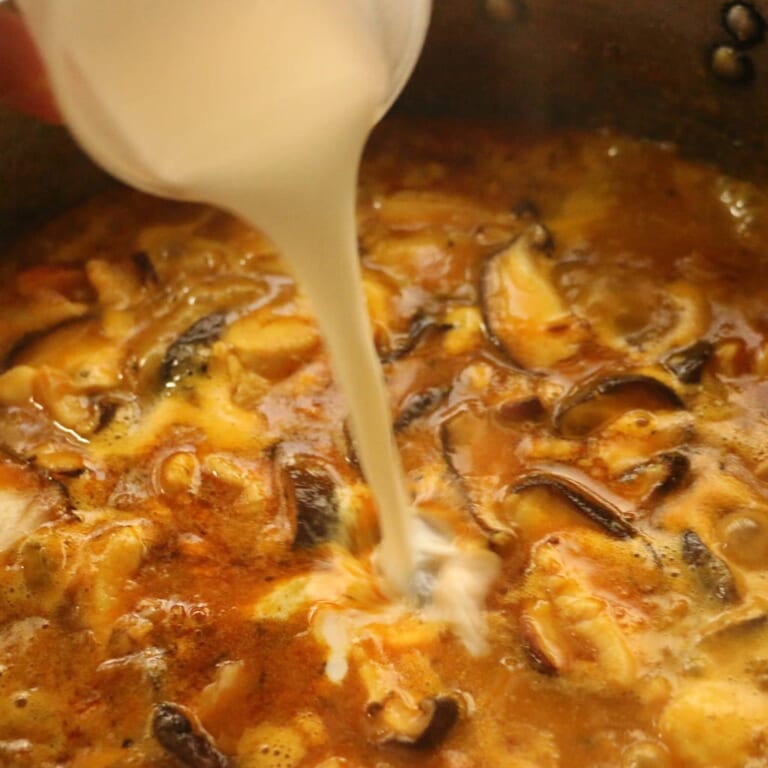 手順 7: 煮立ったら火を弱め、牛乳を加え約5分ほど煮込みます。最後に湯切りした茹でたうどんを加えて完成。お好みで白髪ねぎやミツバな
