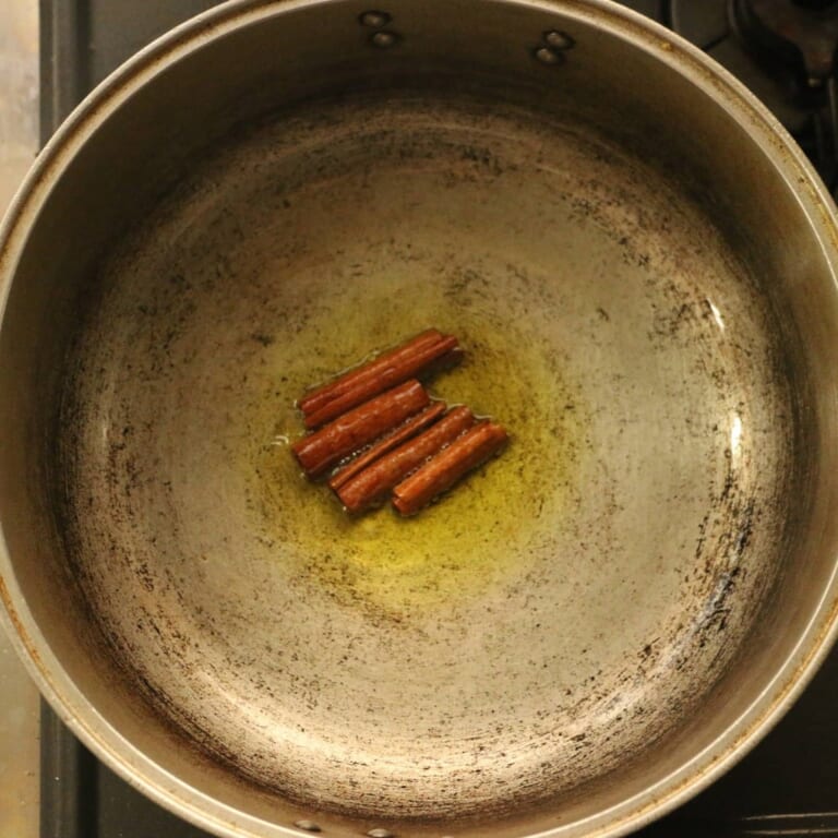 手順 1: 温めたフライパンでサラダ油を熱し、スパイスBを半分に割って加えます。