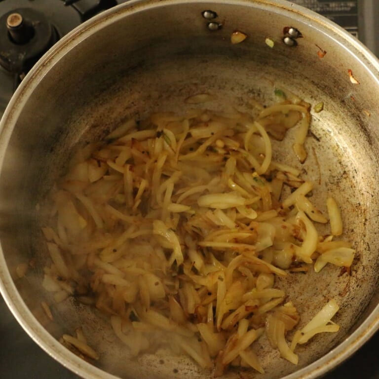 手順 2: 温めたフライパンでサラダ油を熱し、スパイスAを炒めます。 スパイスからシュワシュワと音がしてきたら、玉ねぎを加えます。玉